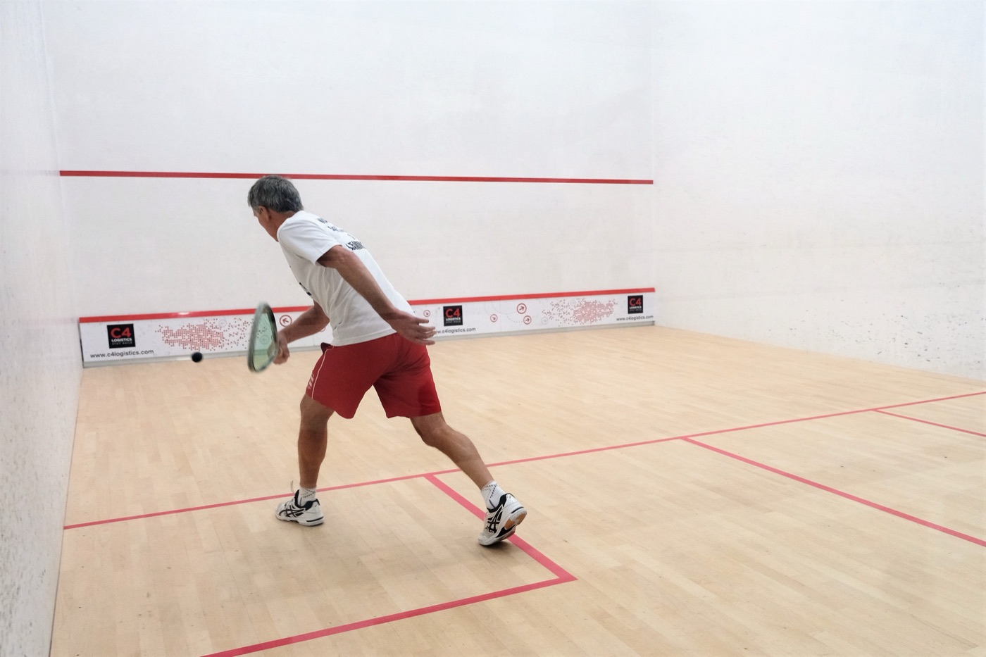 A member playing a shot on one of the club's squash courts