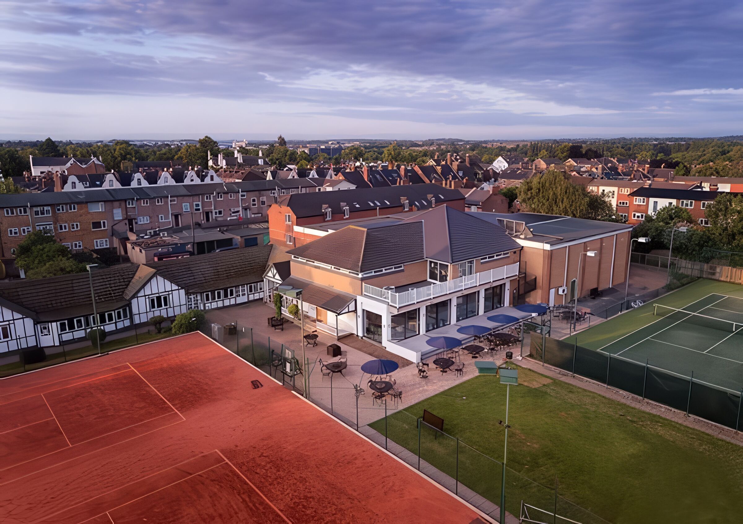 The clubhouse, terrace and courts from the air at golden hour