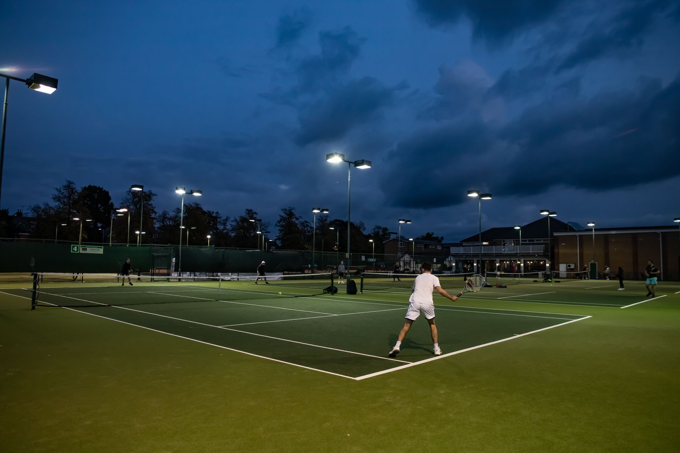 The tennis courts at night under the floodlights