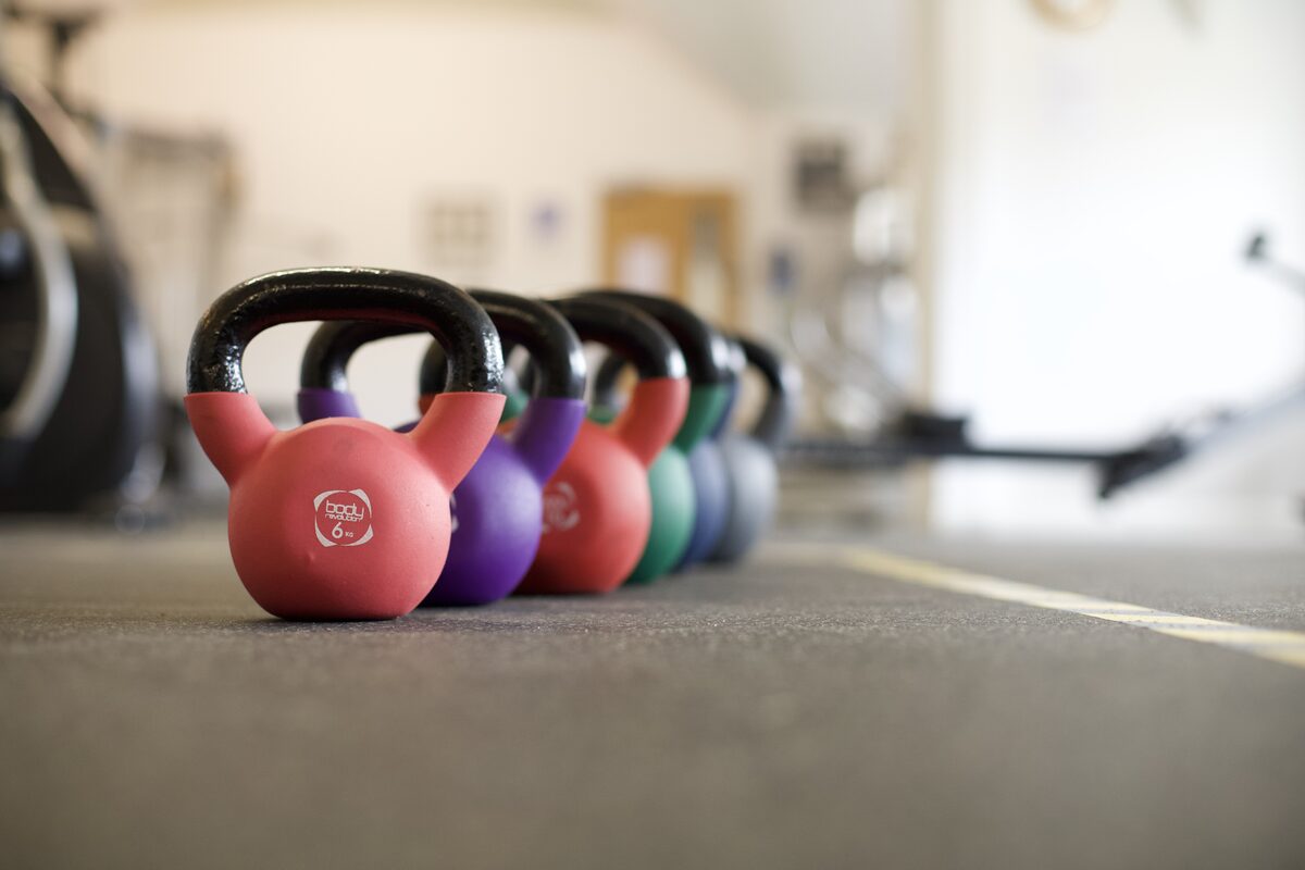 A row of kettlebells on the gym floor