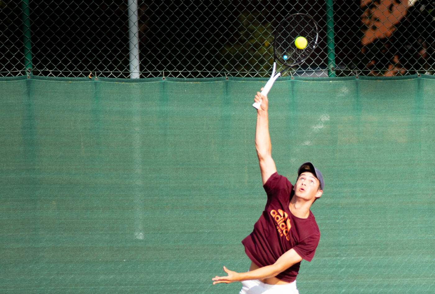 A player serving on the club's tennis courts