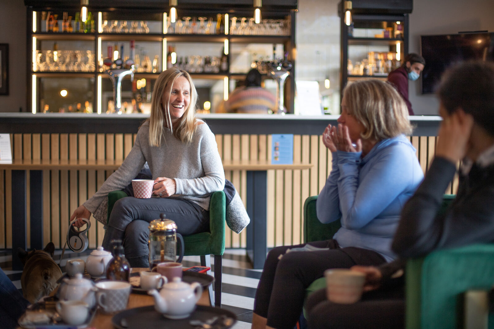 Members laughing over tea in the Hidden Gem